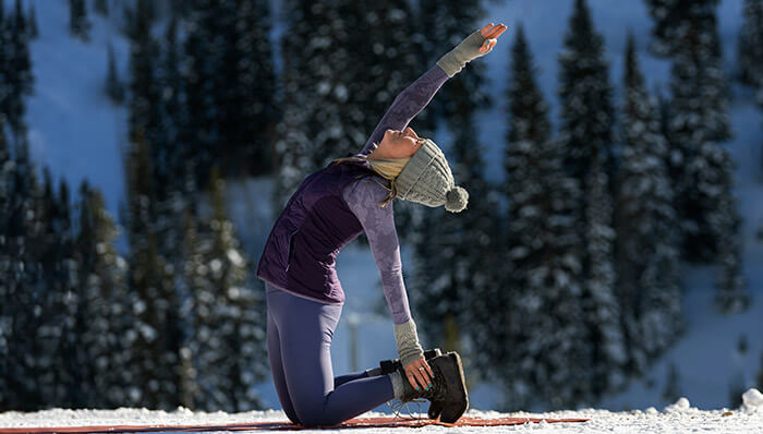 Woman doing a yoga pose outdoors in the snow